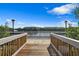 Scenic waterfront view from a wooden dock with a grey railing, ideal for relaxing outdoors at 9998 Key Haven Rd, Seminole, FL 33777