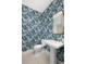 Chic powder room with bold wallpaper, modern fixtures, and a pedestal sink creating a stylish and functional space at 9998 Key Haven Rd, Seminole, FL 33777