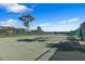 Outdoor tennis court surrounded by green fencing with residential buildings in the background at 9998 Key Haven Rd, Seminole, FL 33777