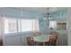 Charming dining area with a table surrounded by four wooden chairs, blue walls and cabinets at 10315 Cortez W Rd # 71-4, Bradenton, FL 34210