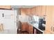 Functional kitchen with wood cabinets, granite counters, and white appliances with hardwood floors at 10315 Cortez W Rd # 71-4, Bradenton, FL 34210