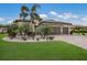 A beautiful single-story home with a three-car garage, manicured landscaping, and a brick paved driveway at 14326 Flat Woods Ter, Lakewood Ranch, FL 34211