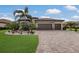 A charming home featuring a three car garage, stone accents, tile roof, and manicured landscaping at 14326 Flat Woods Ter, Lakewood Ranch, FL 34211