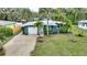 An aerial view of a one story house with a one car garage and large front yard with palm trees at 1604 Edna Ave, Largo, FL 33770
