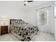 Comfortable bedroom with a tropical themed comforter, ceiling fan, and natural light at 2720 Butterfly Jasmine Trl, Sarasota, FL 34240