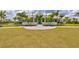The clubhouse stands at the end of a large lawn with landscaped features and trees at 2720 Butterfly Jasmine Trl, Sarasota, FL 34240