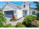 Charming two-story home featuring a blue front door, well-manicured landscaping, and a two-car garage at 2720 Butterfly Jasmine Trl, Sarasota, FL 34240