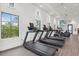 Bright and airy gym featuring treadmills and other cardio machines overlooking lush greenery, promoting an active lifestyle at 2720 Butterfly Jasmine Trl, Sarasota, FL 34240