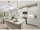 Well-lit kitchen featuring white cabinets, stainless steel appliances, and an island with bar seating at 2720 Butterfly Jasmine Trl, Sarasota, FL 34240