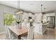 Open concept kitchen and dining area with white cabinetry, stainless steel appliances, and a modern light fixture at 2720 Butterfly Jasmine Trl, Sarasota, FL 34240