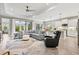 Bright, open-concept living space with tile flooring, a plush sectional sofa, and a modern kitchen in the background at 2720 Butterfly Jasmine Trl, Sarasota, FL 34240