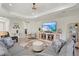 Cozy living room showcasing a large sectional sofa, ottoman, and a cabinet with beach scene displayed on the television at 2720 Butterfly Jasmine Trl, Sarasota, FL 34240