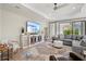 Cozy living room with a large TV, comfortable seating, stylish rug, and lots of natural light at 2720 Butterfly Jasmine Trl, Sarasota, FL 34240