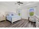 Bright main bedroom with a ceiling fan, tray ceiling, and luxury vinyl plank flooring at 2720 Butterfly Jasmine Trl, Sarasota, FL 34240