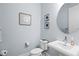 Stylish powder room with a pedestal sink, round mirror, and flower art at 2720 Butterfly Jasmine Trl, Sarasota, FL 34240