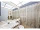 Well-lit bathroom with a large mirror, vanity, and a shower with floral-patterned curtain at 2832 74Th W St # 2180, Bradenton, FL 34209