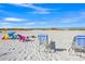 Inviting beachfront with colorful beach chairs and umbrellas, perfect for enjoying sunny days and coastal recreation at 3421 Bayou Sound, Longboat Key, FL 34228