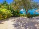 Private backyard with light colored gravel and mature landscaping at 3629 Almeria Ave, Sarasota, FL 34239