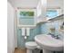 Cozy bathroom featuring charming blue tile, a pedestal sink, and lots of natural light at 3629 Almeria Ave, Sarasota, FL 34239