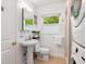 Clean bathroom featuring a pedestal sink, modern vanity mirror, and in-unit washer/dryer at 3629 Almeria Ave, Sarasota, FL 34239