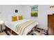 Bright bedroom featuring a cozy bed, colorful rug, and a window view of lush greenery at 3629 Almeria Ave, Sarasota, FL 34239