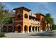 Vibrant exterior view of a commercial building with arched entrances and terra cotta roof tiles at 3629 Almeria Ave, Sarasota, FL 34239