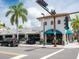 Charming white building with awnings, lush palm trees, and outdoor seating area at 3629 Almeria Ave, Sarasota, FL 34239