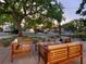 Inviting single-story home with outdoor seating area and a large, mature shade tree in the front yard at 3629 Almeria Ave, Sarasota, FL 34239