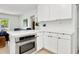 Modern kitchen featuring stainless steel oven, white cabinets, and integrated breakfast bar at 3629 Almeria Ave, Sarasota, FL 34239