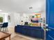 Bright living room with stylish blue sofa, modern decor, and an open entryway at 3629 Almeria Ave, Sarasota, FL 34239