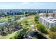 Aerial view of condos and golf course including a pond, under clear skies with trees in between at 3750 Pinebrook Circle # Apt 505, Bradenton, FL 34209