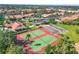 Aerial view showcasing tennis courts amidst a vibrant community with lush landscaping and residential buildings at 3825 Wilshire Cir # 1, Sarasota, FL 34238
