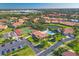 Aerial view of the community featuring a pool, tennis courts, lush landscaping, and a serene pond at 3825 Wilshire Cir # 1, Sarasota, FL 34238