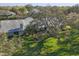 Aerial view of a single-Gathering home showing a green lawn and mature oak trees at 3825 Wilshire Cir # 1, Sarasota, FL 34238