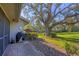 Landscaped backyard features a well-kept lawn, mature trees, and a paved patio area with a grill at 3825 Wilshire Cir # 1, Sarasota, FL 34238