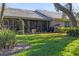 Backyard view featuring lush green grass, mature foliage, and a screened-in porch at 3825 Wilshire Cir # 1, Sarasota, FL 34238