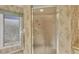 Bathroom showcasing a glass-enclosed shower with patterned wallpaper and bright natural light at 3825 Wilshire Cir # 1, Sarasota, FL 34238