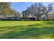 Large, green front lawn leads to a well-maintained home with mature trees and manicured hedges at 3825 Wilshire Cir # 1, Sarasota, FL 34238