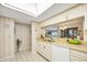 Kitchen with white cabinetry, light countertops, and pass-through to the dining area at 3825 Wilshire Cir # 1, Sarasota, FL 34238