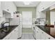 Efficient kitchen featuring white cabinets, black countertops, and essential appliances at 3825 Wilshire Cir # 1, Sarasota, FL 34238
