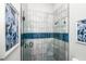 Contemporary shower with gray and white tiling, glass door and blue tiled accents at 401 20Th Pl, Bradenton Beach, FL 34217