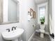 Well-lit bathroom featuring a modern sink, toilet, framed mirror, and a window providing natural light at 401 20Th Pl, Bradenton Beach, FL 34217