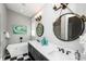 Dual sink bathroom vanity with black and white tile floors and rope-accented mirrors at 401 20Th Pl, Bradenton Beach, FL 34217