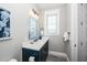 Bathroom with a navy blue vanity, quartz countertop, and soft gray walls at 401 20Th Pl, Bradenton Beach, FL 34217
