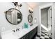 Dual sink bathroom vanity with quartz countertop, black and white tile floors, and rope mirrors at 401 20Th Pl, Bradenton Beach, FL 34217