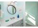 Bathroom with a round rope mirror over vanity, pink flamingo art, and a toilet at 401 20Th Pl, Bradenton Beach, FL 34217