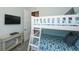 Light blue bunk bedroom featuring a white bunk bed, TV, and light-colored wood flooring at 401 20Th Pl, Bradenton Beach, FL 34217