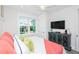 Bright bedroom featuring a comfortable bed with stylish decor, a dresser, and natural light from the window at 401 20Th Pl, Bradenton Beach, FL 34217
