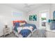 Bedroom with a ceiling fan, balcony access, coastal art, and colorful bedding at 401 20Th Pl, Bradenton Beach, FL 34217