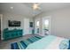 Open bedroom featuring gray wood floors, a ceiling fan, and water views through glass doors at 401 20Th Pl, Bradenton Beach, FL 34217